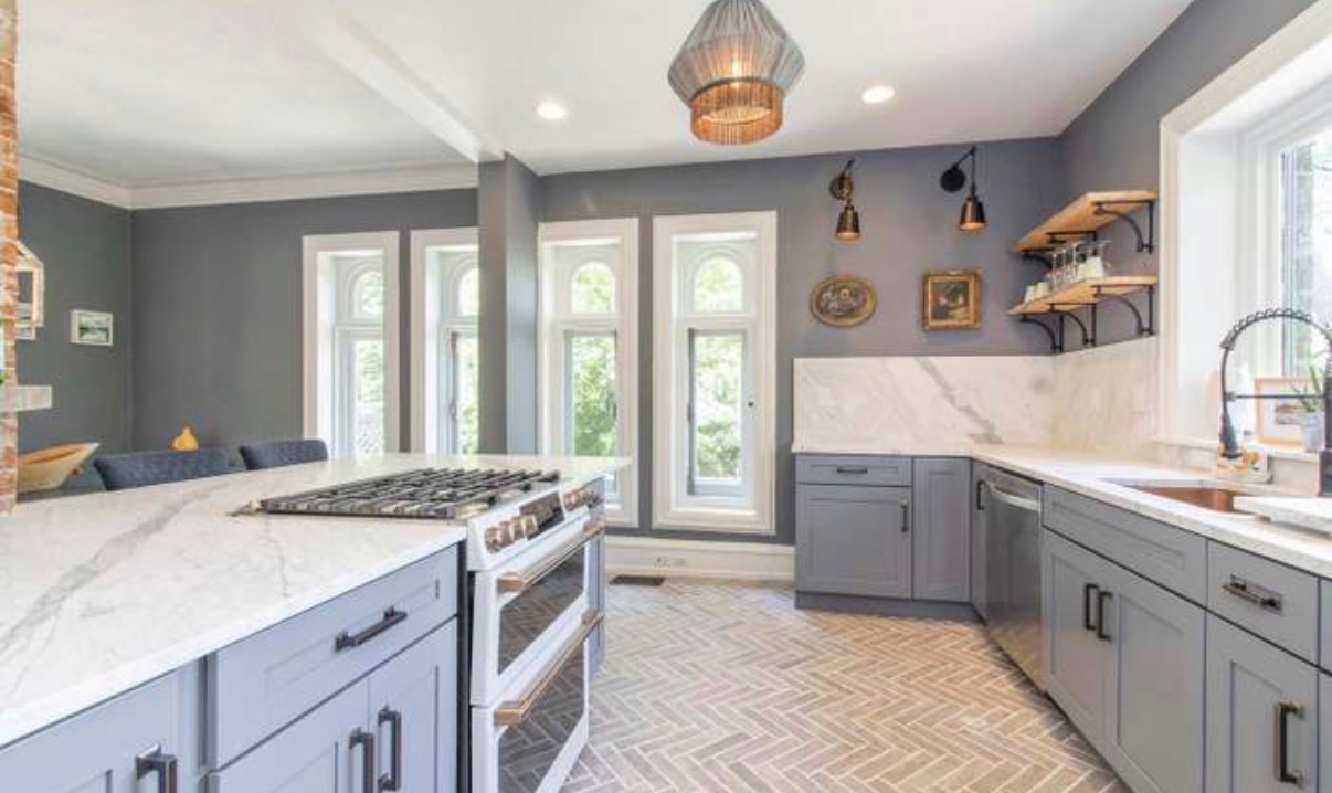 Kitchen with arched gothic windows, marble counters, and herringbone brick floor